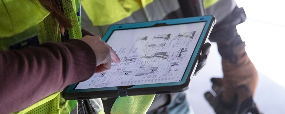 Construction workers using Autodesk on a tablet